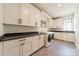 A laundry room features ample cabinet space, black countertops, and modern washer/dryer at 410 Mcalway Rd, Charlotte, NC 28211