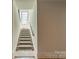 Carpeted staircase with wood railing leads to the upper level and features light walls at 410 Mcalway Rd, Charlotte, NC 28211