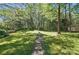 Spacious backyard featuring lush lawn and stone pathway leading to a bird bath at 505 Southland Rd, Huntersville, NC 28078