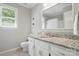 Bright bathroom featuring a granite countertop vanity and natural light from the window at 505 Southland Rd, Huntersville, NC 28078