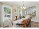 Sunlit dining room with a long wooden table, elegant chairs, and large windows at 505 Southland Rd, Huntersville, NC 28078