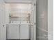 Functional laundry closet with washer, dryer, and wire shelving at 505 Southland Rd, Huntersville, NC 28078