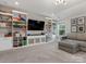 Spacious basement area with built-in shelving, TV, and comfortable seating at 5078 Hyannis Ct, Matthews, NC 28104