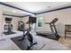 Bright home gym featuring a stationary bike, treadmill, and large mirror at 5078 Hyannis Ct, Matthews, NC 28104
