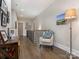Bright hallway featuring a reading chair, table, and dark hardwood floors at 5078 Hyannis Ct, Matthews, NC 28104