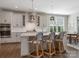 Modern kitchen featuring white cabinets, quartz countertops, stylish pendant lights, and wood flooring at 5078 Hyannis Ct, Matthews, NC 28104