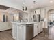 Contemporary kitchen island featuring a sink, dishwasher, and stylish pendant lighting at 5078 Hyannis Ct, Matthews, NC 28104