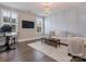 Comfortable living room with a sofa, desk, chandelier, and large windows for ample natural light at 5078 Hyannis Ct, Matthews, NC 28104