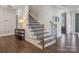 Elegant staircase with wooden steps, black iron railings, and natural light at 5078 Hyannis Ct, Matthews, NC 28104