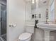Well-lit bathroom boasts a pedestal sink, toilet, and glass enclosed shower with modern fixtures at 517 Wingrave Dr, Charlotte, NC 28270