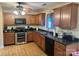 Well-appointed kitchen with wood cabinets, black appliances, and tiled floors at 5228 Sunriver Rd, Gastonia, NC 28054