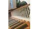 Staircase with yellow-striped non-slip treads, wooden railing, and carpet runner at 5228 Sunriver Rd, Gastonia, NC 28054