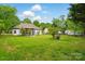 Large green backyard with ample space, landscaping, and side view of the house at 530 Dovefield Dr, Indian Trail, NC 28079