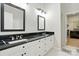 Bright bathroom with dual sinks, black marble countertops, white cabinets, and a walk-in closet at 530 Dovefield Dr, Indian Trail, NC 28079
