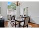 Elegant dining room with a glass-top table, chandelier, and large window at 530 Dovefield Dr, Indian Trail, NC 28079