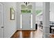 Bright entryway featuring hardwood floors, white trim, and elegant transom window above door at 530 Dovefield Dr, Indian Trail, NC 28079