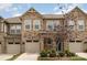 Charming townhome featuring stone accents, a tan garage door, and a well-maintained yard at 5684 Garrow Glen Rd # 96, Charlotte, NC 28278