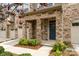 Inviting townhome entrance featuring stone columns, a blue front door and manicured landscaping at 5684 Garrow Glen Rd # 96, Charlotte, NC 28278