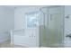 Bright bathroom featuring tub, glass shower, and a window with natural light at 5808 Mcdowell Run Dr, Huntersville, NC 28078