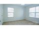 Cozy bedroom featuring two windows, neutral walls, and carpet flooring at 5808 Mcdowell Run Dr, Huntersville, NC 28078