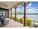 Back porch with stone floors, wood columns, ceiling fan, and a view of the lake at 602 Shoreline Rd # 144, New London, NC 28127