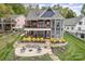 Gorgeous backyard features a stone patio with fire pit and a covered deck overlooking manicured landscaping at 602 Shoreline Rd # 144, New London, NC 28127
