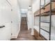 Hallway with hardwood floors, stairs, bunkbeds, and multiple doors with modern hardware at 602 Shoreline Rd # 144, New London, NC 28127