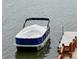 Pontoon Boat covered with a white tarp tied down at the dock at 602 Shoreline Rd # 144, New London, NC 28127