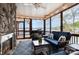 Screened-in porch with lake views, stone fireplace, ceiling fan, and wicker seating at 602 Shoreline Rd # 144, New London, NC 28127