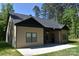 Back exterior view of this charming home, featuring siding, black roof, a patio, and green lawn at 6519 Pargo Rd, Charlotte, NC 28216