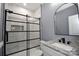 Modern bathroom featuring tiled walk-in shower with glass door, granite vanity and rectangular mirror at 6519 Pargo Rd, Charlotte, NC 28216