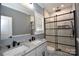 Modern bathroom features double sink vanity, granite countertop, and tiled glass-enclosed shower at 6519 Pargo Rd, Charlotte, NC 28216