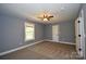 Bright bedroom featuring neutral carpet and walls, a ceiling fan, and a window for natural light at 6519 Pargo Rd, Charlotte, NC 28216