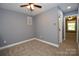Bedroom features neutral walls, ceiling fan, carpet, white trim, and doorway to another room at 6519 Pargo Rd, Charlotte, NC 28216