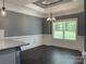 Dining room featuring decorative ceiling trim, wainscoting, chandelier, gray walls, and dark wood floors at 6519 Pargo Rd, Charlotte, NC 28216