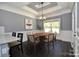 Dining room featuring modern chandelier, decorative ceiling trim, and a round wood table with six chairs at 6519 Pargo Rd, Charlotte, NC 28216