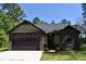 Charming single-story home featuring stone accents, a dark gray roof, and a two-car garage at 6519 Pargo Rd, Charlotte, NC 28216