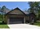 Charming single-story home with a black garage door and stone and siding details, surrounded by green trees at 6519 Pargo Rd, Charlotte, NC 28216