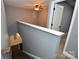 Hallway featuring a staircase with gray walls, leading to a doorway with white doors and neutral carpeting at 6519 Pargo Rd, Charlotte, NC 28216