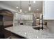 Modern kitchen with white cabinets, granite countertops, stainless steel appliances, and stylish pendant lighting at 6519 Pargo Rd, Charlotte, NC 28216