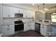 Bright kitchen featuring stainless steel appliances, granite countertops, white cabinets, and dark hardwood floors at 6519 Pargo Rd, Charlotte, NC 28216