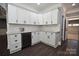 Bright kitchen featuring white cabinets, marble backsplash, wine fridge, and dark wood floors at 6519 Pargo Rd, Charlotte, NC 28216