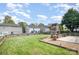 Expansive backyard with a stone fireplace, a well-maintained lawn, and a charming fence at 6618 Latherton Ln, Charlotte, NC 28278