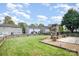 Spacious backyard with a stone fireplace, a well-maintained lawn, and a charming fence at 6618 Latherton Ln, Charlotte, NC 28278