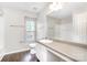 Clean bathroom featuring a single sink vanity, shower-tub combo, and a window for natural light, creating a functional space at 6618 Latherton Ln, Charlotte, NC 28278
