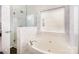 Luxurious bathroom features a soaking tub, separate glass enclosed shower, and a window for natural light, creating a relaxing retreat at 6618 Latherton Ln, Charlotte, NC 28278