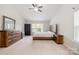 Cozy bedroom featuring a ceiling fan, natural light, a wooden dresser and bed frame, creating a warm and inviting atmosphere at 6618 Latherton Ln, Charlotte, NC 28278