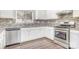 Well-lit kitchen with stainless steel appliances, white cabinets, and grey tile backsplash at 6618 Latherton Ln, Charlotte, NC 28278