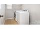 Functional laundry room featuring a washer, dryer, and shelving for storage, making laundry chores more convenient at 6618 Latherton Ln, Charlotte, NC 28278