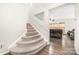 Carpeted staircase leading to a bright living room with hardwood floors and comfortable furnishings at 6618 Latherton Ln, Charlotte, NC 28278